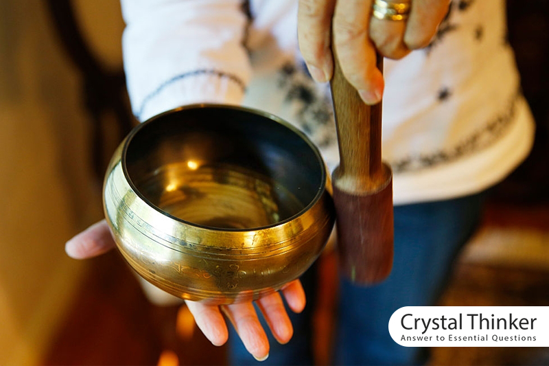 A small golden Tibetan bowl in a woman's hands
